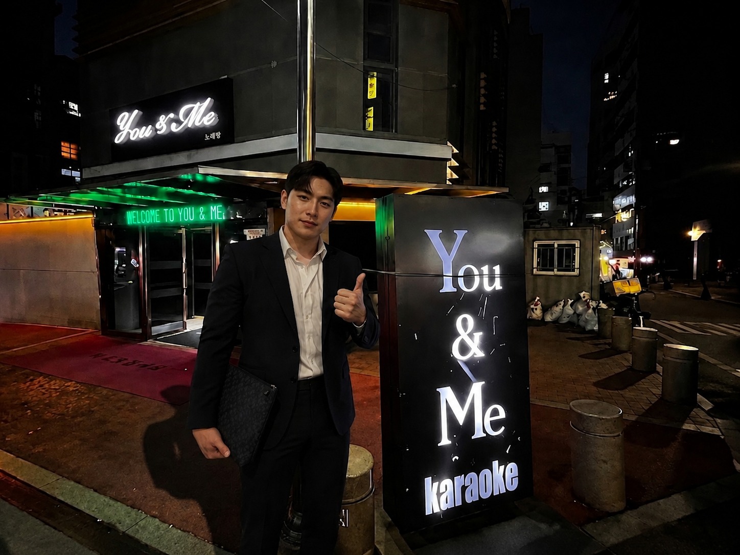 강남 유앤미 가라오케 입구 — 신사역 티롤호텔 You & Me 간판 앞에 선 안대표